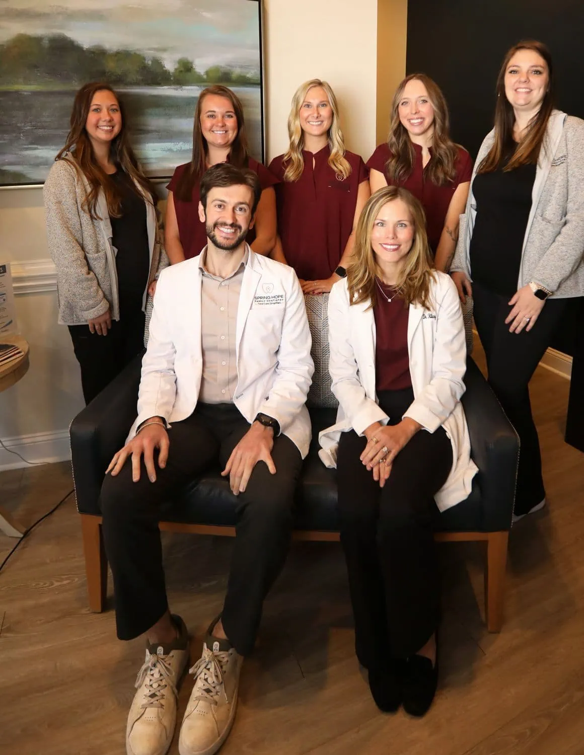 Dr. Abboud and Dr. Hilary seated with the Spring Hope Family Dentistry team in the office lounge