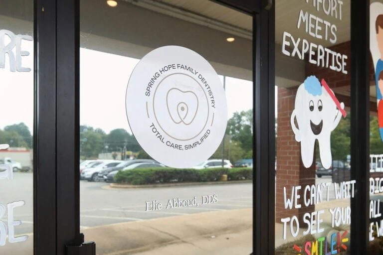 Front door of Spring Hope Family Dentistry at 615 E Nash St in Spring Hope, NC, with our logo on the glass
